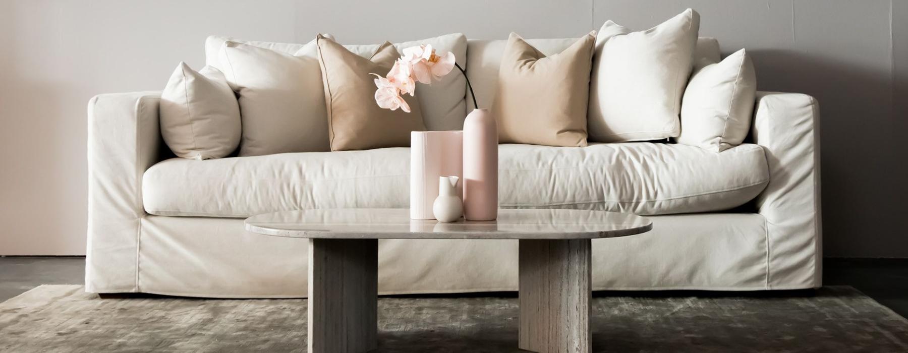 living room with a large couch and vases on a coffee table