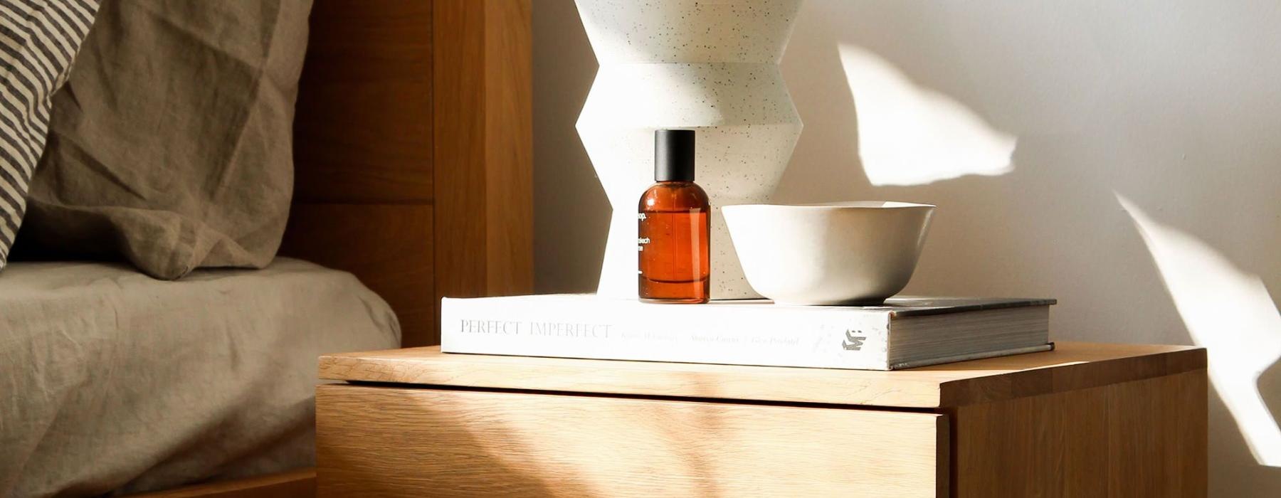 a vase with cotton stems on a bedside table