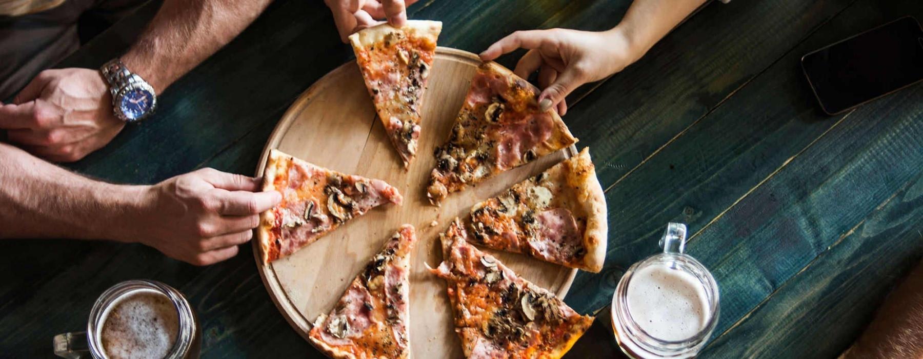 a group of people eating pizza